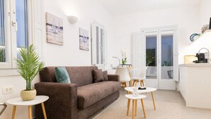 Un salon moderne avec un canapé marron, des tables rondes blanches et une plante en pot.