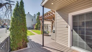 Puinen terassi, jossa on pergola, ruukkuistutuksia ja esteetön näkymä kadulle.