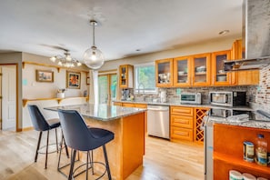 A modern kitchen with granite countertops, stainless steel appliances, and wooden cabinetry. - Explore the White Mountains! Spacious Rural Home (Thornton)