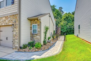A residential property with a stone facade, a garage, and a landscaped front yard with a pathway.