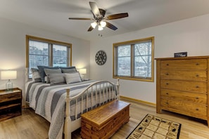 A bedroom with a bed, a wooden dresser, a nightstand, a ceiling fan, and a wall clock. - Rocky Mtn-View Retreat! Walk to Dtwn Grand Lake (Grand Lake)