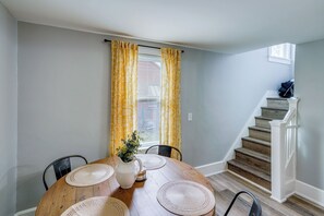 A dining area with a round wooden table, four chairs, a pitcher, and a plant. - Hudson Valley Retreat! Convenient Apt in Kingston (Kingston)