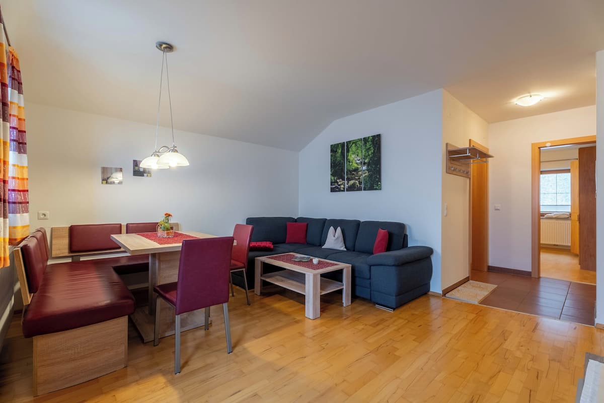 Una sala de estar con un sofá, mesa de comedor, sillas y una mesita de centro.
