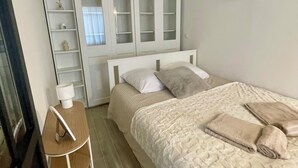 Una camera da letto con un letto, un comodino, uno specchio e un armadio.