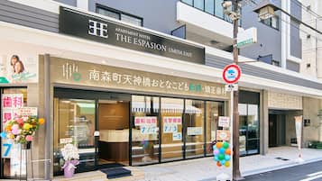 A building with a sign for 'The Espasion N Umeda East' and a no-parking sign.