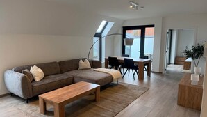 Uma sala de estar moderna com sofá, mesa de centro e área de jantar.