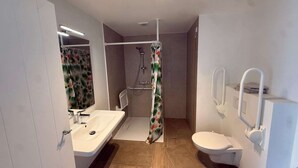 A bathroom with a shower, toilet, sink, and a mirror. - Modern apartment Hasselt 2p (Hasselt)