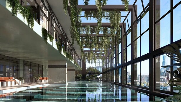 Piscina interior moderna con paredes de vidrio, vegetación y vista a la ciudad.