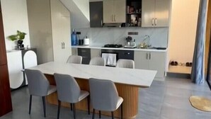 A modern kitchen with a central island, grey chairs, and a dining table. - Villa Casa Casar in Paje Zanzibar for rent (Sansibar)