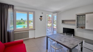 Eine moderne Küche mit Essbereich, großen Fenstern und Blick auf einen Pool.