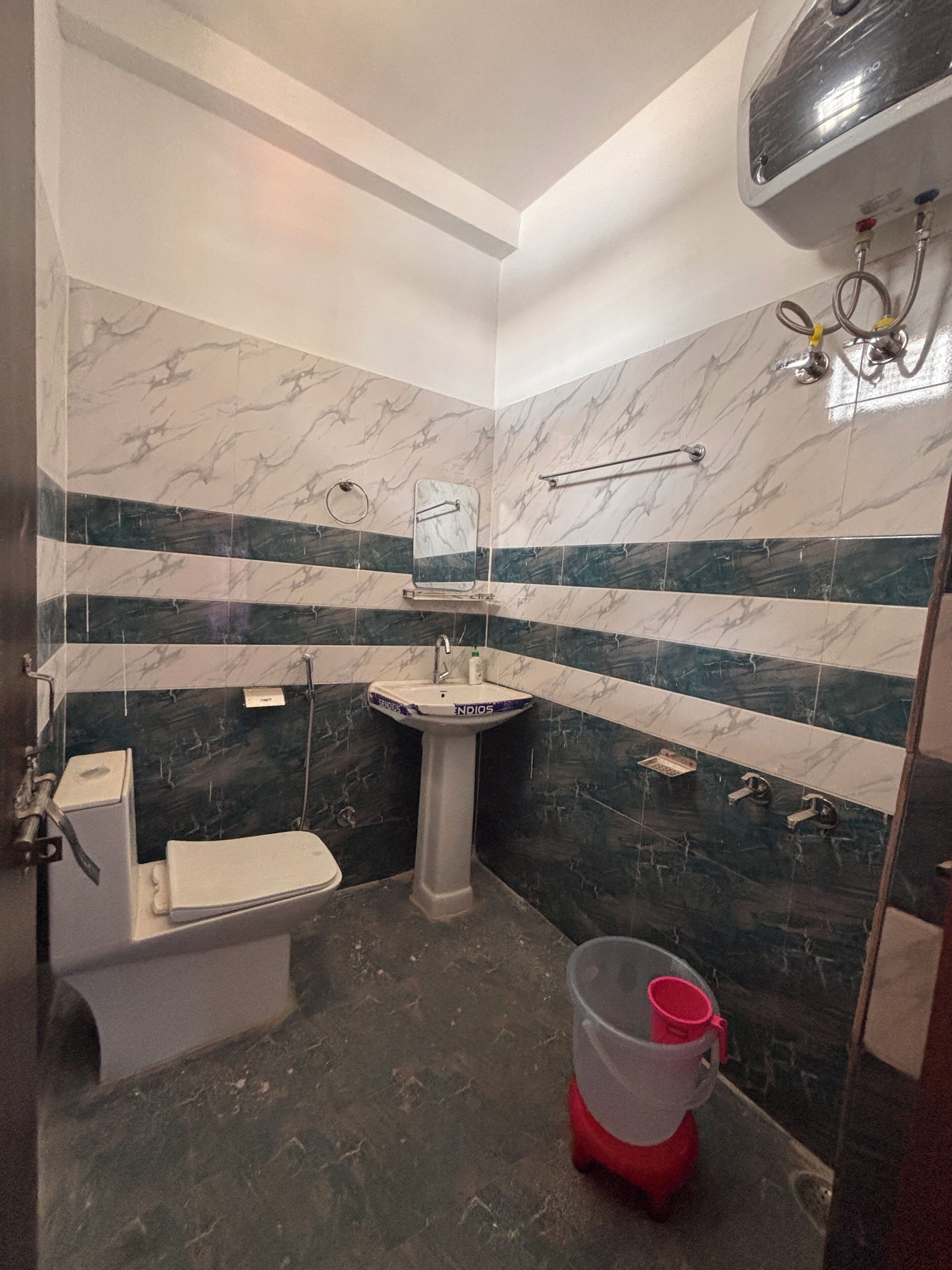 A bathroom with a toilet, sink, and shower area.