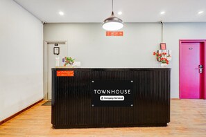 Una recepción con el rótulo 'TOWNHOUSE' y un cartel que indica que el servicio es proporcionado por la empresa.