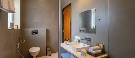 A modern bathroom with a shower, toilet, and sink.
