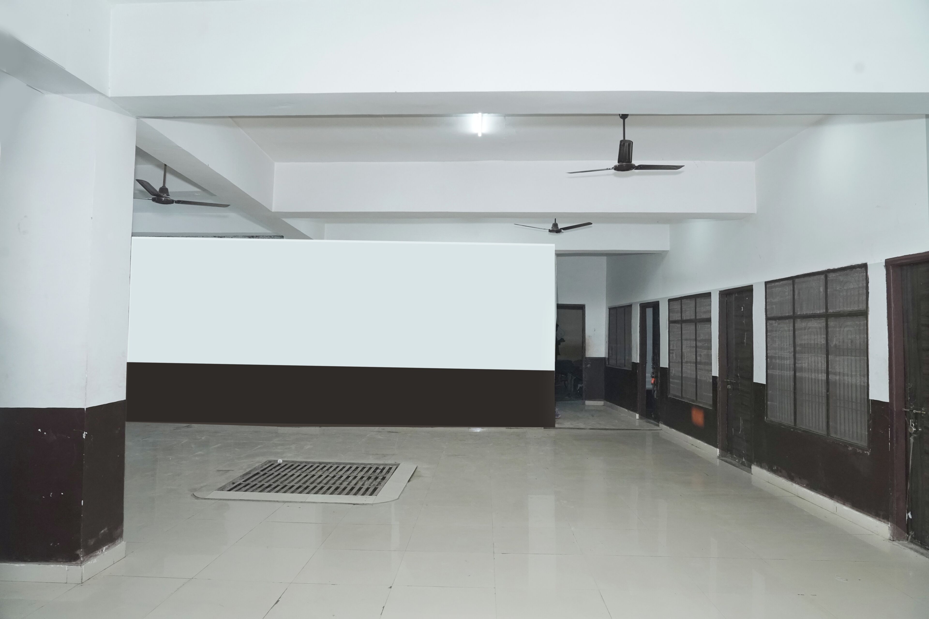 A corridor with ceiling fans, a vent, and a door at the end.
