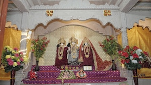 A shrine with religious statues, flowers, and ritual items. - Omji Ashram Varanasi (Varanasi)