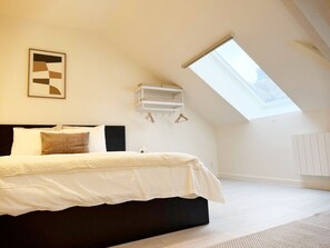 A bedroom with a bed, a skylight, a wall-mounted shelf, and a framed picture. - Spacious Rooms 15 Min to City Center (Ghent)