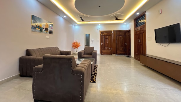 Un salon moderne comprenant un canap é, une table basse et un téléviseur fixé au mur.
