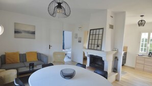 Ein modernes Wohnzimmer mit Kamin, Esstisch und einer Couch.