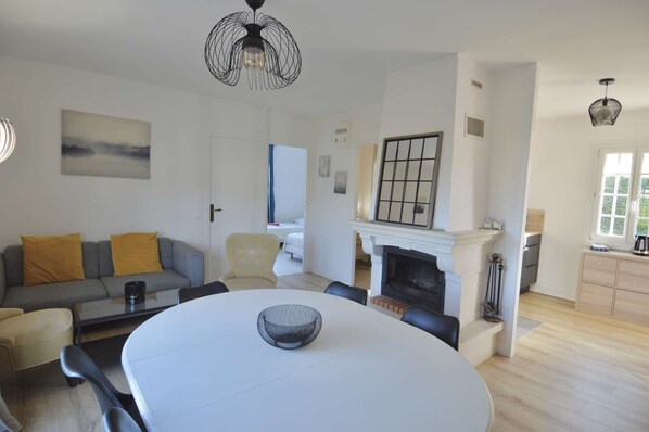 Un salon moderne avec une chemin ée, une table à manger et un canapé.