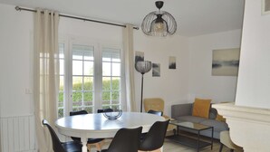 Ein Essbereich mit einem runden Tisch, schwarzen Stühlen und einer Stehlampe.