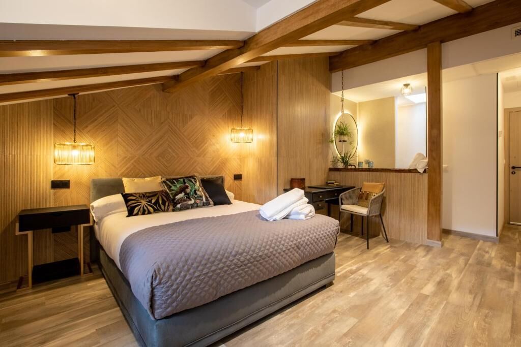 Une chambre à coucher avec un lit, des tables de chevet, un bureau et une chaise.
