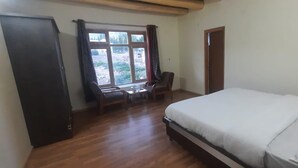 Una camera da letto con un letto, una scrivania, una sedia, un armadio e una finestra.