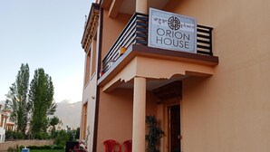 Un hotel chiamato 'Orion House' con un balcone, piante in vaso e posti a sedere all'aperto.