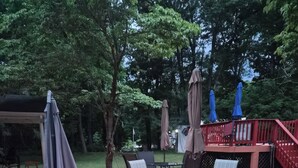 A covered patio with outdoor furniture, a red deck, and a red railing. - HIdden Gem (Wallkill)