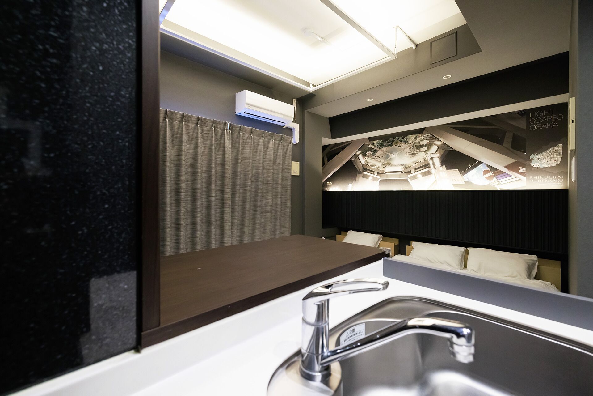 A modern bathroom with a large mirror, a sink, and a shower area.