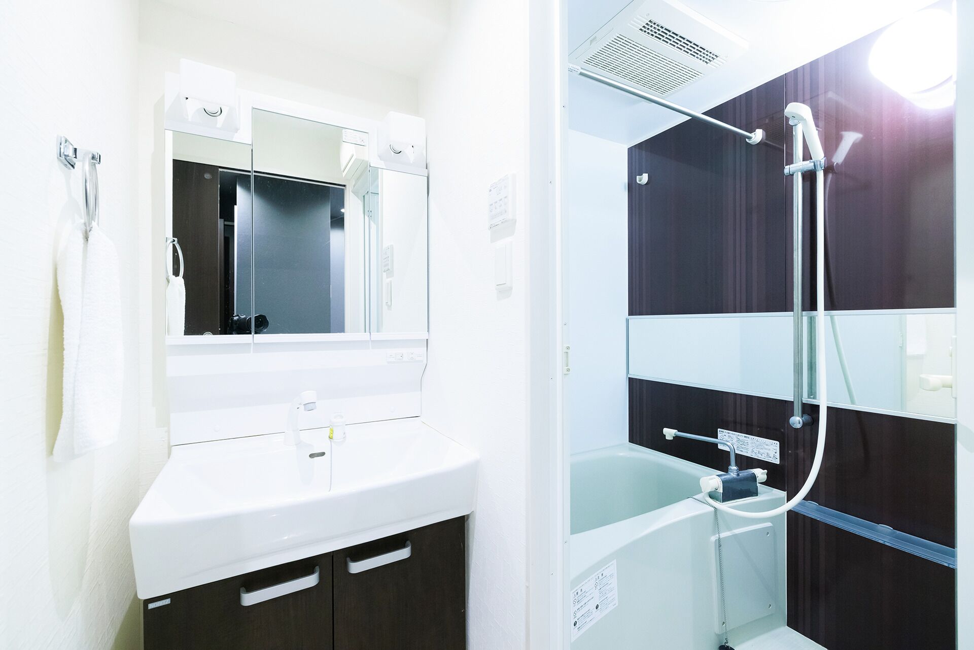 A bathroom with a white sink, mirror, and shower.