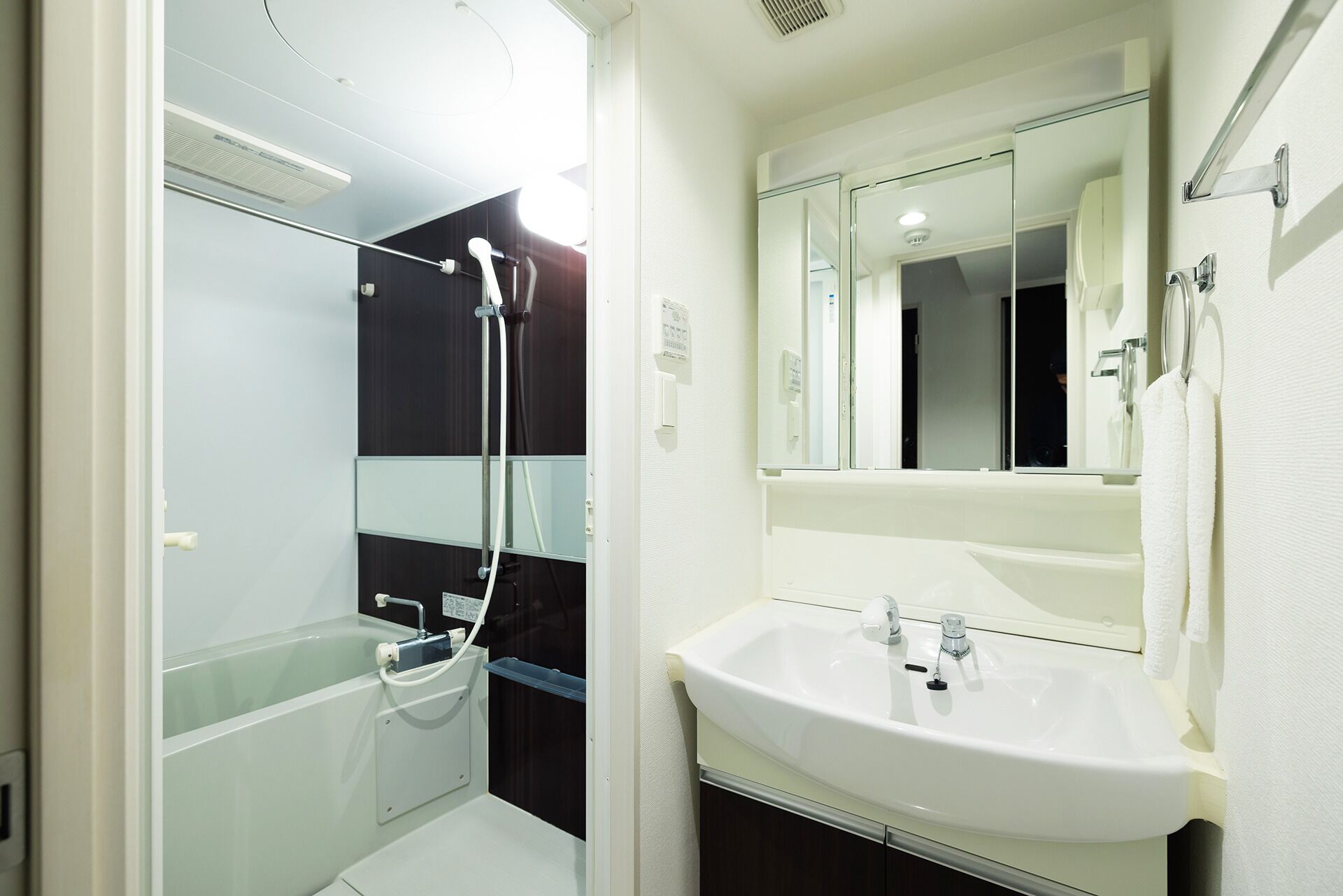 Une salle de bain avec une douche à parois de verre, un lavabo blanc et un miroir.