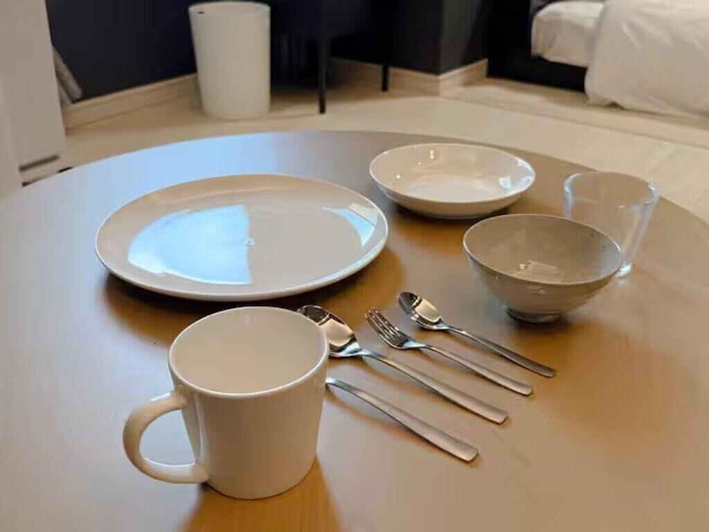 A dining table with plates, a mug, and cutlery.
