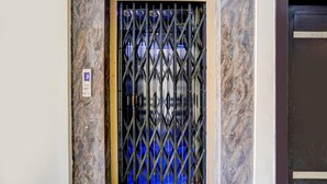 A door with a metal security gate, a marble wall, and a sign with the number 403. - Premium Sanjeevi Residency (Rajahmundry)