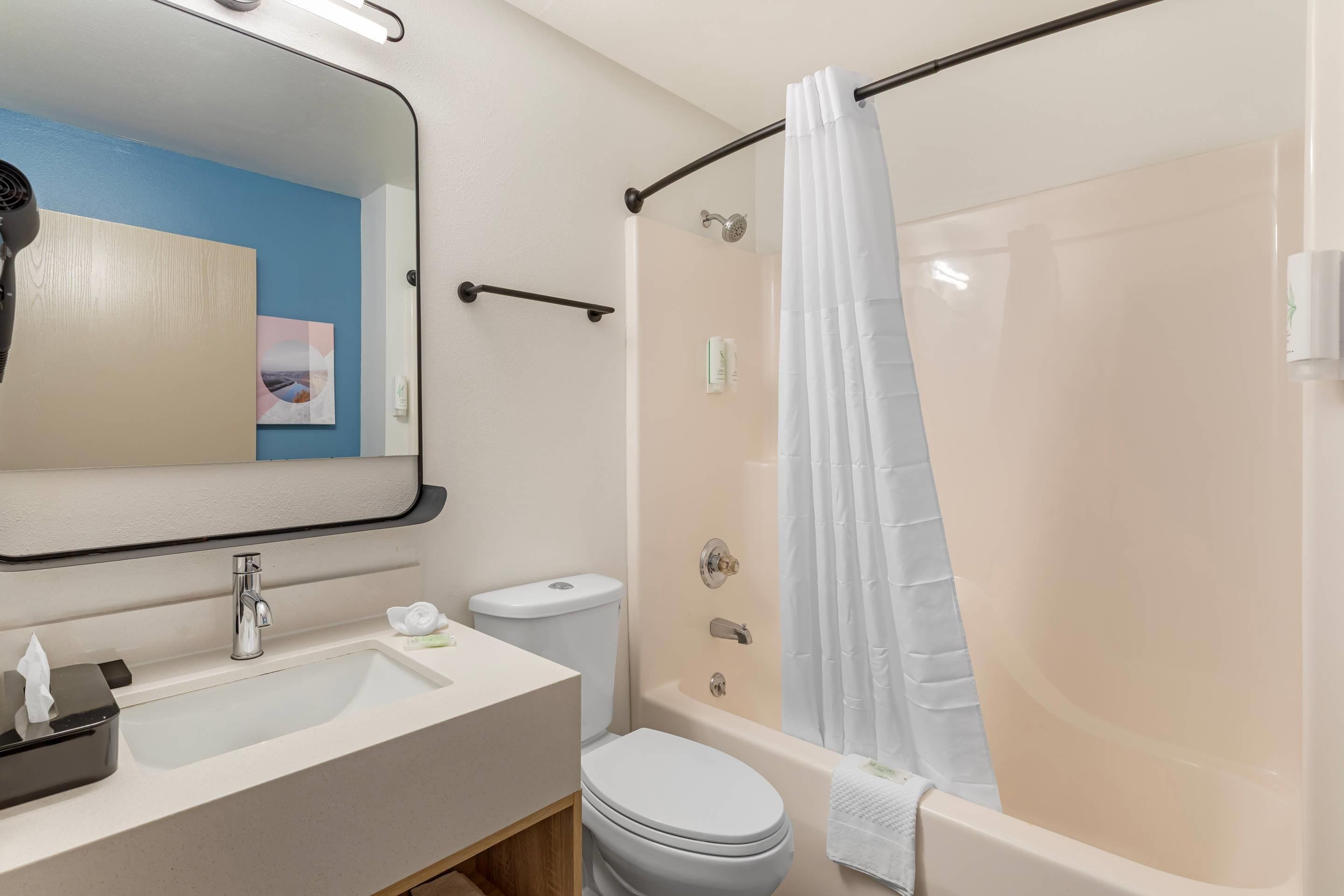 Een badkamer met een wastafel, toilet en bad.