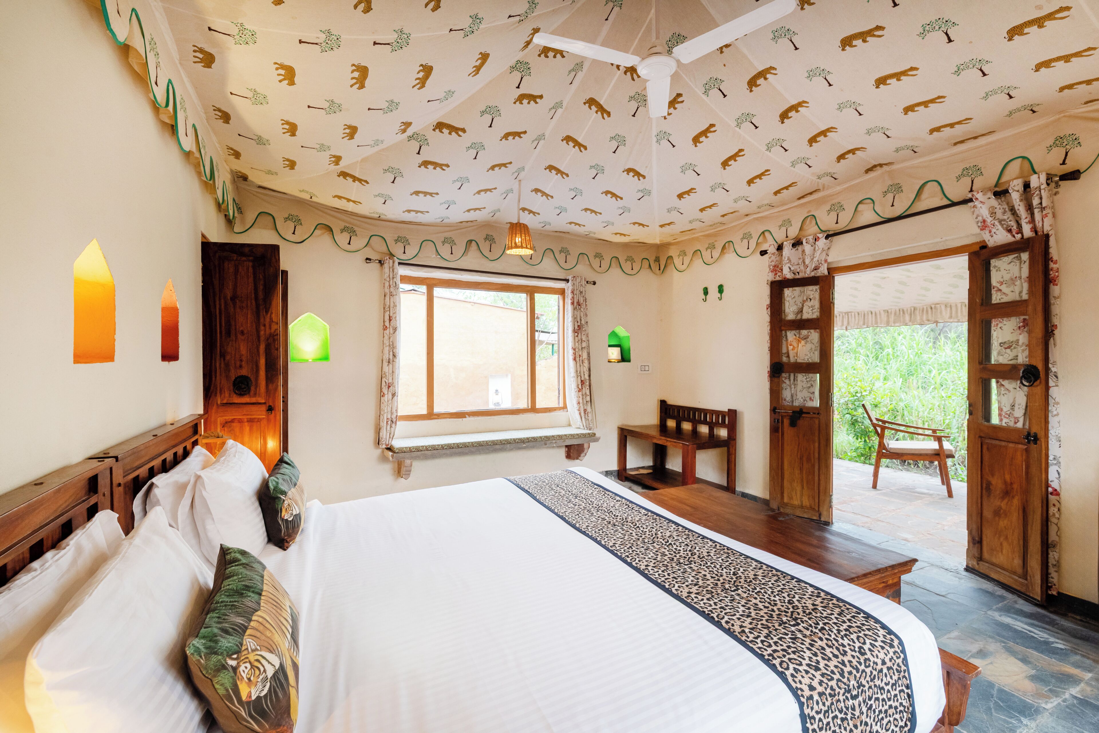 A bedroom with a bed, a window, a chair, and a door leading to an outdoor area.