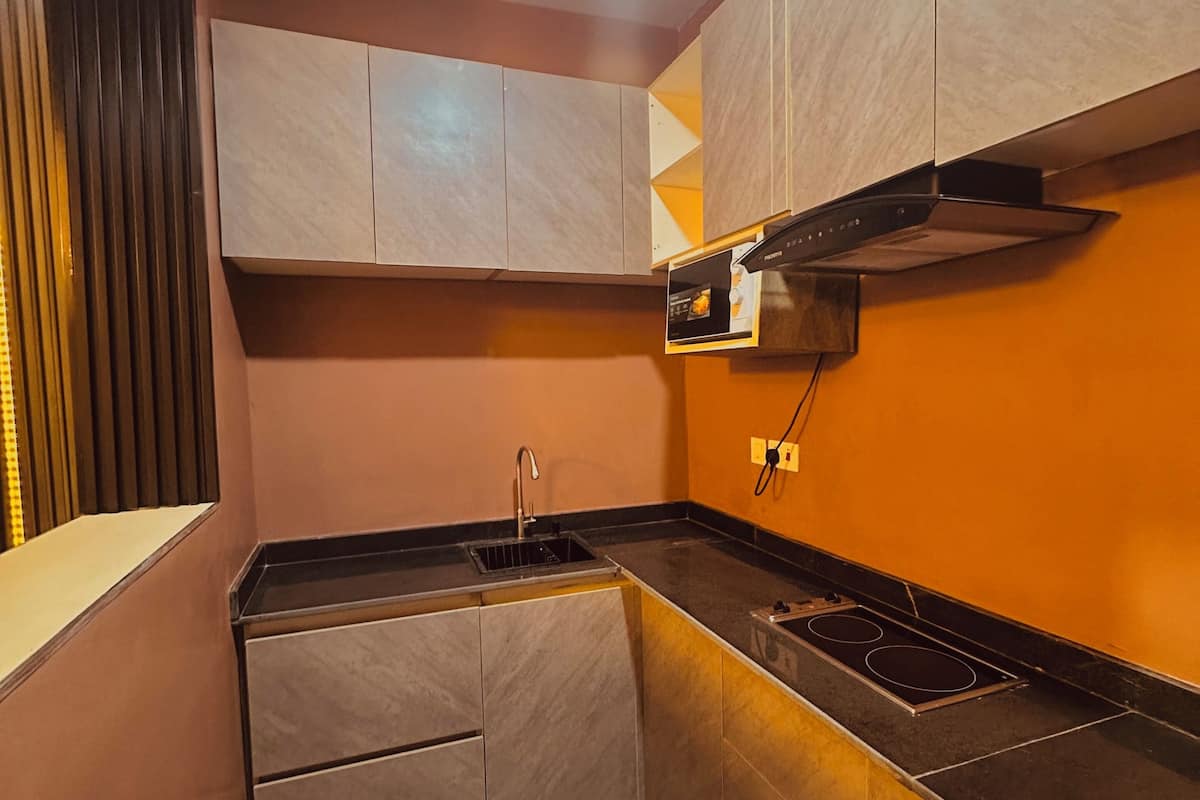 A compact kitchen with a built-in oven, a sink, and a stove.