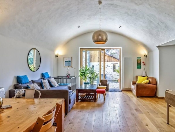 Ein gemütliches Interieur mit einem Holztisch, einer Couch und einem Sessel.