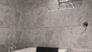 Een badkamer met een wit bad, een toilet en een douche.