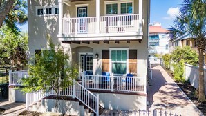 Ein zweistöckiges Gebäude mit Balkon, Eingangstür und kleiner Veranda.