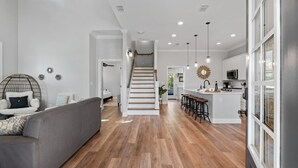 Ein modernes Interieur mit Treppe, einer Küchenzeile und einer Sitzecke.