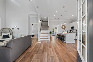 Un intérieur moderne comprenant un escalier, un coin cuisine et un espace salon.