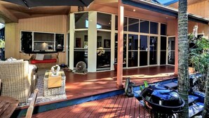 Uma casa moderna com varanda coberta, janelas amplas e móveis de exterior.