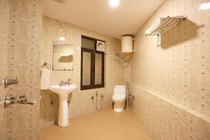 Een badkamer met een wastafel, spiegel, toilet en handdoekhouder.