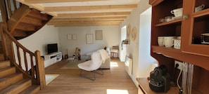 A wooden staircase, a white sofa, a white chair, a television, a coffee table, and a shelf with cups. - House with a view of the mountains, St. Jacques des Blats, Lioran. (Saint-Jacques-des-Blats)