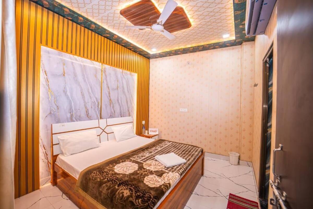 Un dormitorio con cama, ventilador de techo, mesita de noche y aire acondicionado instalado en la pared.