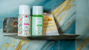 Deux bouteilles de lotion pour le corps et de shampoing sont posées sur une étagère.