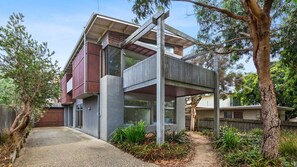 A modern two-story house with a balcony, surrounded by trees and a gravel path. - Kingsley - Point Lonsdale (Point Lonsdale)