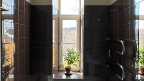 Casa de banho moderna com banheira, lavatório, uma planta em vaso e janela com vista.