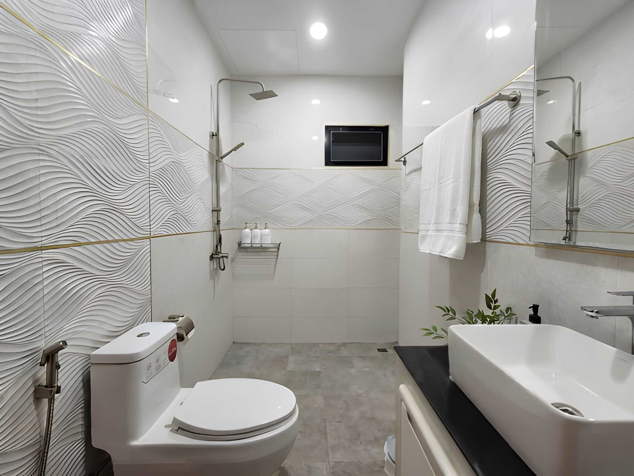 A modern bathroom with a toilet, sink, and shower.