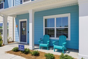 A two-story house with a blue exterior, a front porch with two Adirondack chairs, and a 'Private Residence' sign. - Ocean Breeze Stay and Play! 3BR + Game Room (Panama City Beach)